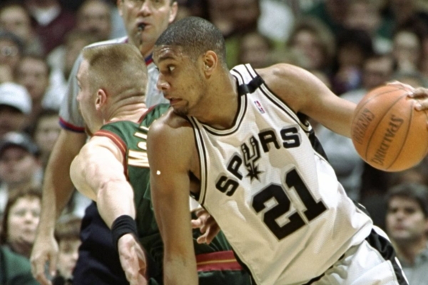 Regata San Antonio Spurs 1998/99 Mitchell & Ness em branco, cinza e preto, destacando a vitória nas Finais da NBA contra o New York Knicks. Adquira com 10% de desconto na primeira compra e frete grátis para todo o Brasil na Tevo Sports.