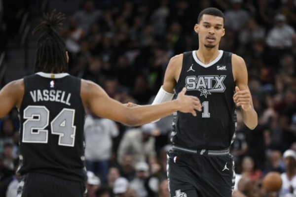 Regata Statement Edition San Antonio Spurs Nike 2022/25 em prata, preto e branco, com logotipos Texas e SATX. Detalhes inspirados em ponchos mexicanos, símbolos da Jordan Brand e NBA. Exclusividade e estilo em cada costura.