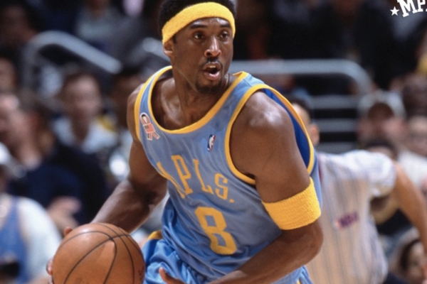 Regata Throwback Mitchell & Ness Lakers 2001/02 em azul claro e amarelo, homenageando a temporada histórica da NBA. Detalhes autênticos celebram Shaquille O'Neal, Kobe Bryant e o título de 2002 | Tevo Sports