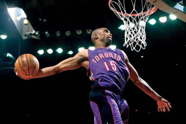 Regata Away Toronto Raptors Mitchell & Ness 1999/03 em roxo, preto, branco e vermelho, representando a era épica da NBA entre 1999 e 2003, liderada por Vince Carter.