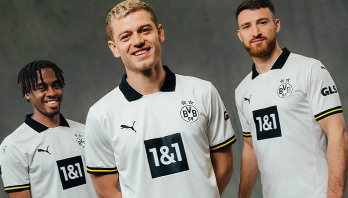 nova terceira camisa do Borussia Dortmund para a temporada 2024/2025. A camisa é predominantemente branca, com detalhes em preto e amarelo, como a gola polo, os punhos e o escudo do clube. Na nuca, o lema "Borussia Verbidet" está escrito em preto.