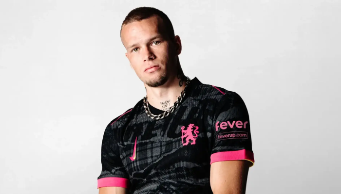 A terceira camisa do Chelsea Nike 2024-2025 apresenta um design inspirado no movimento punk dos anos 70, com o preto como cor predominante e detalhes em rosa e amarelo que remetem aos locais de encontro dos torcedores.