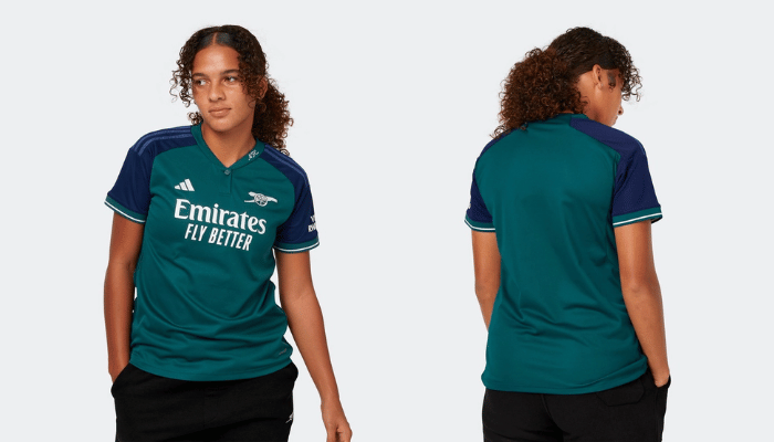 Terceira Camisa Feminina do Arsenal Adidas 2023/24 em verde e azul marinho, com canhão bordado, bainha droptail e gola Henley. Tecnologia AEROREADY, materiais reciclados e inserções laterais em malha para conforto diário.