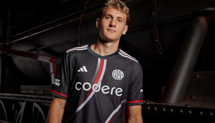 Terceira camisa oficial do River Plate para a temporada 2024-2025. A camisa é cinza grafite ("carbono") com faixas curvas em branco e vermelho que se dissolvem em um degradê. A gola é redonda na mesma cor da camisa, as mangas e os punhos também são da mesma cor e têm detalhes em vermelho. Na nuca, a data de fundação do clube "1901" está em branco. O escudo do River Plate está aplicado no lado esquerdo do peito em branco, com apenas o monograma circular "CARP".