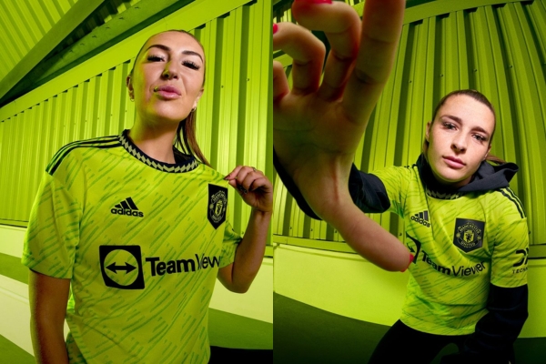 Terceira Camisa Feminina Manchester United Adidas 2022/23 em verde limão e preto, com padrão de triângulos e gola redonda azul marinho. Escudo do United e logo Adidas em destaque.