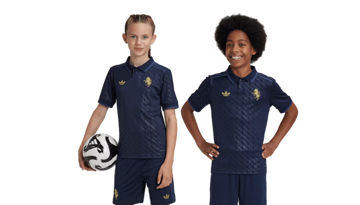 Terceiro conjunto infantil da Juventus Adidas 2024-2025. Camisa azul meia-noite com padrão gráfico jacquard inspirado no reflexo da lua na abóboda celeste. Gola polo com detalhes em tons mais claros e mesmo padrão nos punhos. 