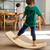 niño balanceándose en tabla curva Montessori