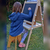 niña pintando con tiza en atril de madera con rollo de papel