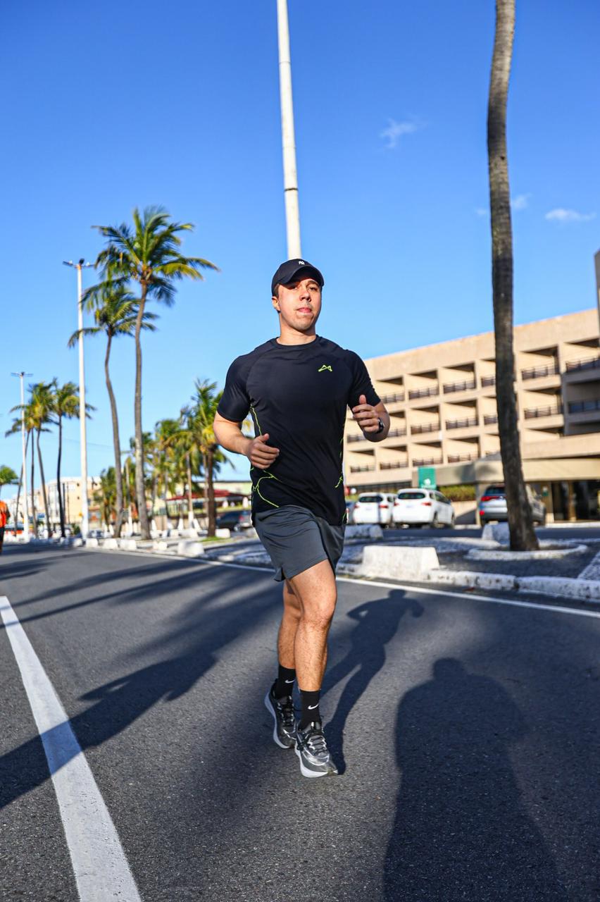 Foto de homem correndo na orla de Aracaju com camiseta ATLET