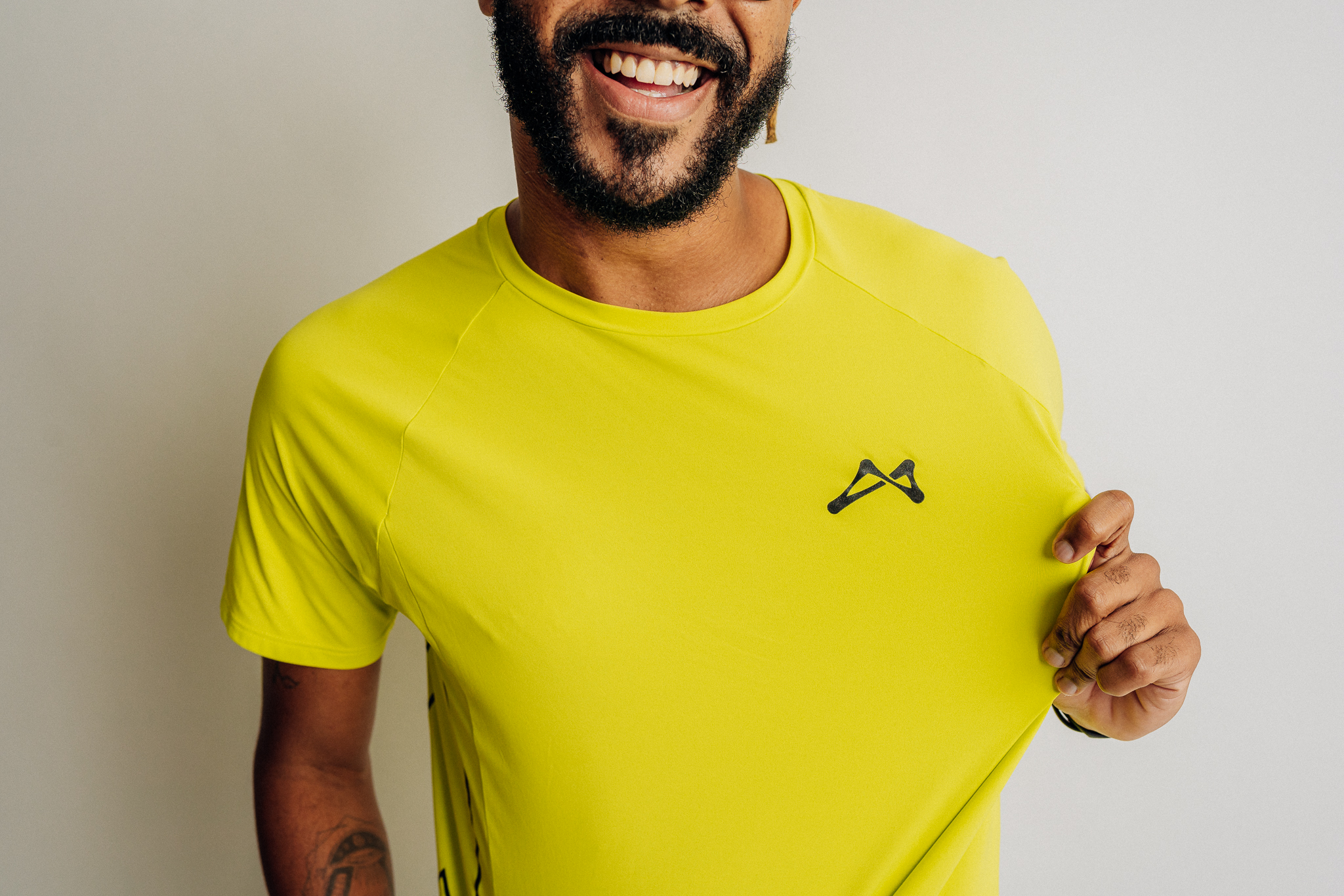 Homem sorrindo com a camiseta de 100% poliamida verde neon da ATLET