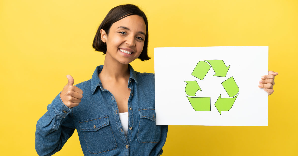 jovem segurando uma placa com símbolo de reciclagem