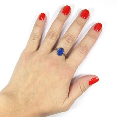 detalhe na mão do anel semijoia de pedra oval cristal azul safira leitoso com aro torcido banhado a ródio negro