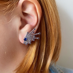detalhe na orelha do brinco semijoia earcuff setas cravejado de zircônias azuis safira banhado a ródio branco