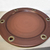 Base marron circular, con apliques dorados en internet