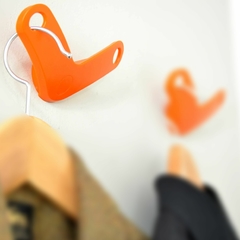 dos percheros de pared color naranja con ropa colgada 