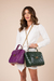 Mulher de branco com bolsas rosa e verde.