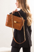 Mulher com bolsa marrom de pirarucu