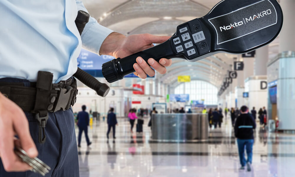 Detector de Metal Portátil Para Segurança Nokta Makro sendo mostrado no aeroporto